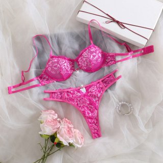 Sexy lace bra set for women in vibrant pink, featuring intricate floral patterns and matching thong, displayed with soft rose...