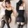 Woman modeling black mannyqing sensual lace bodysuit dress with sheer backless design and thigh-high stockings.