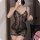 Woman wearing sheer black lace lingerie sleep dress, flirty and feminine bedroom outfit with floral details.