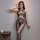 Woman wearing qingyeguo sheer mesh bodysuit with open-crotch design and matching stockings, posing on a bed.