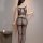 Woman wearing qingyeguo sheer mesh bodysuit with open-crotch design and matching stockings, back view.