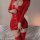 Woman wearing shiny red pvc leather bodycon dress with front zipper, long sleeves, and matching thigh-high boots.