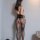 Woman wearing qingyege sheer mesh bodysuit with open-crotch design and matching lace-top stockings, back view.