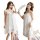 Woman wearing white lace sleep dress with sheer backless design, romantic lingerie set for bedroom.