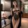 Woman wearing a black lace bodysuit and robe in a modern room.