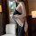 Woman wearing black pure temptation lingerie set, featuring a seductive halter top and high-cut bottoms with side cutouts.
