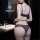 Woman wearing purple lace lingerie set in bathroom, featuring sheer bra and matching panties from pure & seductive collection...