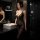 Woman in black sheer bodysuit with floral lace, posing by bathroom sink – seductive no-remove bodysuit set for women.
