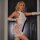 Woman modeling white glow-in-the-dark mesh two-piece dress set with uv reactive lingerie design and no-remove feature.