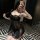 Woman posing in mirror wearing black sheer lace sleepwear set with chest-baring cami and shorts, stylish lounge outfit.