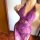 Woman wearing a purple plus size lace bodysuit with sheer mesh, adjustable ties, and a busty fit up to 200 lbs.