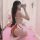 Woman wearing plus size maid costume with red ribbons and white apron, kneeling on pink carpet in mirror selfie.