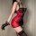 Woman wearing red and black lace lingerie set with gloves and stockings, side view.