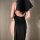 Woman wearing black plus size nun costume with high slit and lace trim, back view showing open design for adult role play.