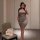 Woman in a sleek, form-fitting silver dress poses for a mirror selfie. a bouquet of pink roses rests on a nearby chair.