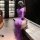 Woman in purple lace nightgown with side slit, taking a mirror selfie in a modern room.