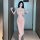 A woman poses confidently wearing a form-fitting, blush-colored sheer mesh nightgown with a deep v-neckline and lace trim det...