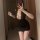 Woman wearing black lace ol style bodycon dress, plus size sexy secretary outfit with deep v neckline and short skirt.