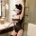 Curvy woman in black lace bodysuit with cat ears, showcasing the plus size busty lingerie set in a modern bathroom setting.