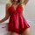 Woman wearing a red lace and satin sleepwear set with a bow detail.