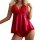 Woman wearing red lace and satin sleepwear set with bow detail, featuring sheer lingerie top and matching shorts for alluring...
