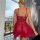 Woman wearing red lace lingerie set, backless sheer bodysuit sleepwear on balcony with city view.