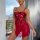 Woman wearing red 2025 luxury lace lingerie set – sheer backless bodysuit with bow detail, standing by window.