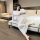 A woman poses elegantly on a bed wearing a sheer white long-sleeve nightgown dress, highlighting its form-fitting design and ...