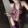 Woman wearing purple lace neck-hanging bodysuit with heart cutouts and sheer waist-cinching design, paired with matching thig...