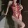 Woman wearing red lace neck-hanging bodysuit with heart cutouts and sheer waist-cinching design.