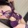 Woman wearing purple lace lingerie set with bows, featuring sheer floral details and cutouts for date nights.