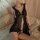 Woman wearing black lace sleep dress with ruffles, sheer fabric, and deep v-neckline on a bed. flirty pure-temptation lingeri...