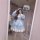 A woman poses in a mirror wearing a light blue 2026 cute sweet lolita dress, featuring long sleeves, ruffled layers, and flor...
