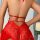 Back view of woman wearing red lace lingerie chemise with adjustable straps and sheer floral detail.