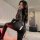 Woman modeling black lace bodysuit with dual zippers and open-crotch design, sheer long sleeves, plus size fit.