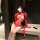 Woman wearing red sheer lace bodysuit with open-crotch mesh design, long gloves, and ribbon details.