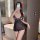 Woman wearing black sheer lace sleepwear set with transparent mesh, posing in bathroom mirror selfie.