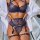 Woman wearing navy lace lingerie set with garter straps and open robe, showcasing elegant seductive design.