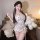 Woman modeling floral lace low-cut cami and bodycon sleep dress with sheer mesh details, styled with ribbons and thigh-highs.