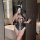 Woman in sheer black rabbit girl lingerie set with bunny ears, holding a whip, posing in a modern bathroom.