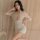 Woman wearing a sexy lace lingerie set with short sleeves, featuring a deep v-neck and high-waisted design, perfect for sleep...
