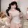 Woman modeling pink bunny maid costume with sheer mesh, lace trim, and ruffled apron, holding teddy bear.