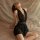 Woman wearing black deep v neck sleep dress with sheer mesh backless design, elegant plus size lingerie set for nightwear.