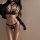 Woman modeling black lace tie-back bikini set with gold chains, sheer cups, and strappy design—seductive lace tie-back bikini...