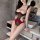 Woman wearing red and black cherry romance lingerie set with sheer bodysuit in modern bathroom setting.