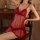 Woman wearing a red plus size lingerie sleep set with sheer fabric and lace details, sitting on a wooden chair.