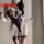 Woman modeling a purple bodysuit with white lace trim and sheer ruffles, paired with matching garters.