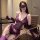 Woman modeling purple lace lingerie set with sheer embroidered bra, panties, gloves, and garter straps in office chair.