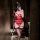 Woman in red lace lingerie set with sheer mesh and thigh-high stockings, taking a mirror selfie.