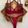 Wine red plus size lingerie set featuring a sheer mesh bra and panty with lace cutouts, displayed on a wooden tray.